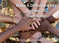 A diverse group of people putting their hands on top of each others' hands in a circle